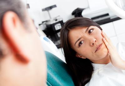 woman holding jaw in pain before root canal in royal palm beach