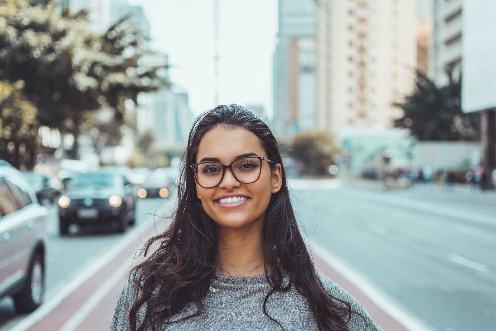 clear braces | woman smiling while standing in royal palm beach