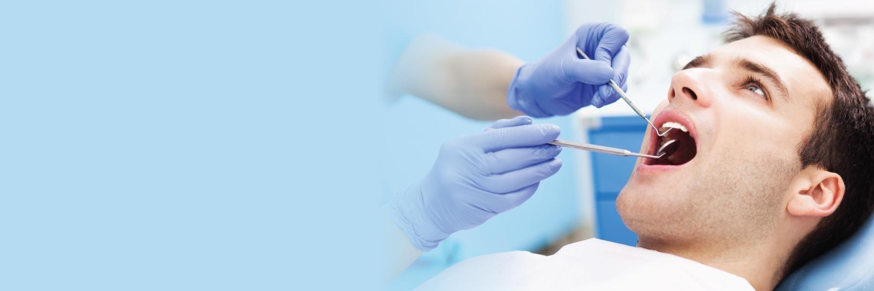 Man getting dental exam in Wellington dental office
